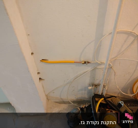 צינור גז צהוב מחובר לקיר עם מחברים